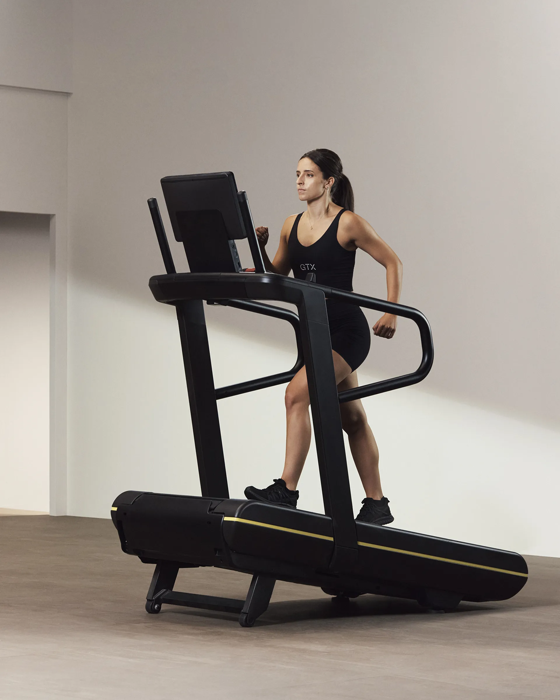 A Life Time member walking on an incline treadmill.